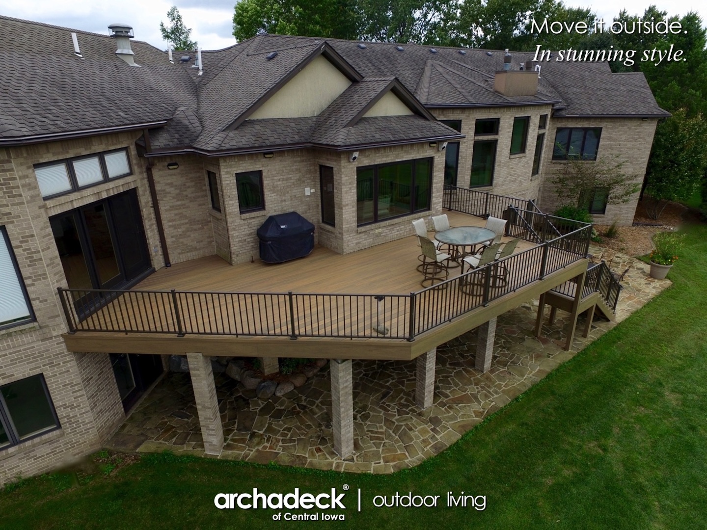 A large house with a deck and a lawn